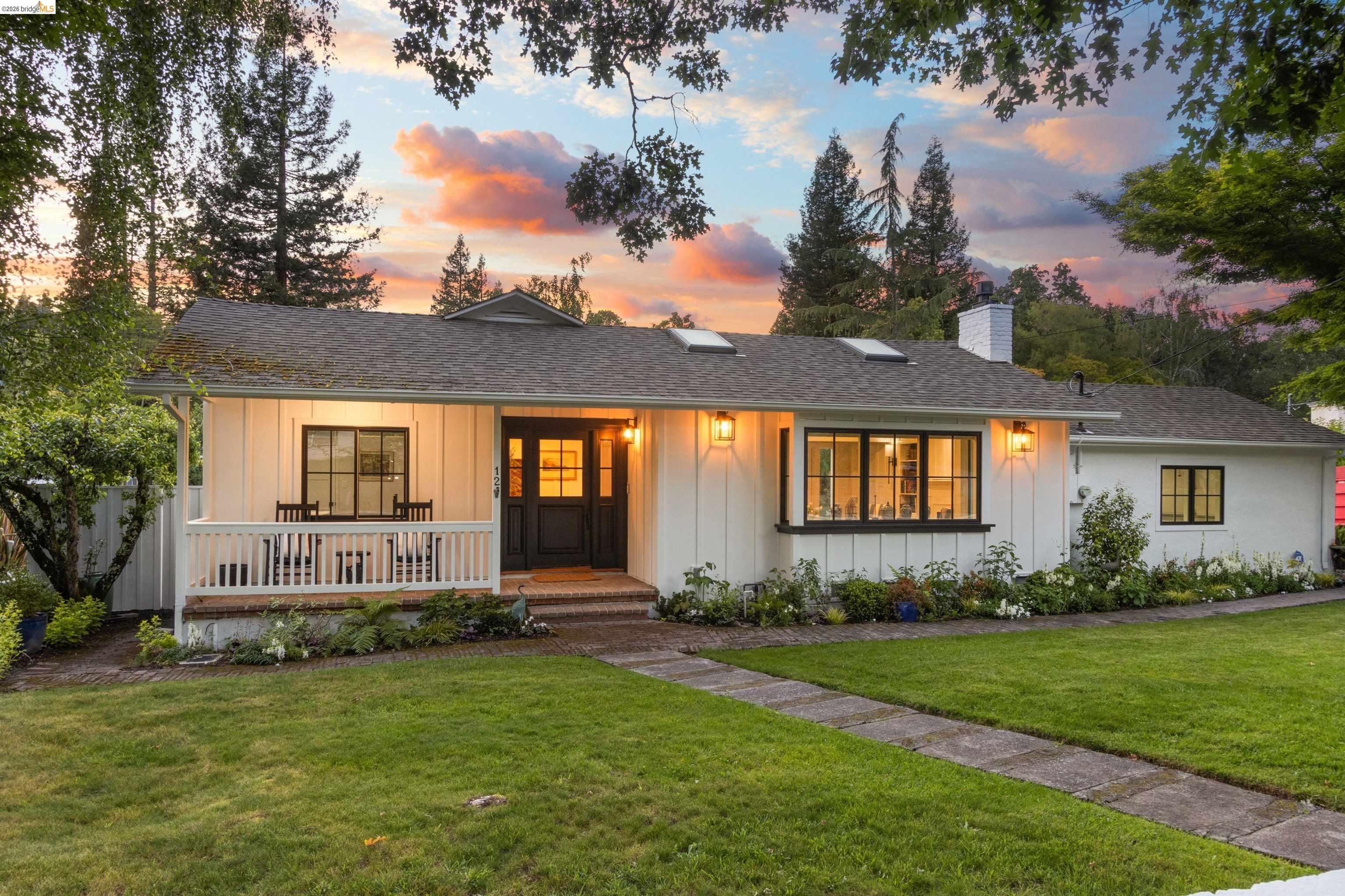 12 Woodland Road Orinda, CA 94563 - Photo 1 of 1 White board-and-batten exterior featuring a covered front porch with white railing