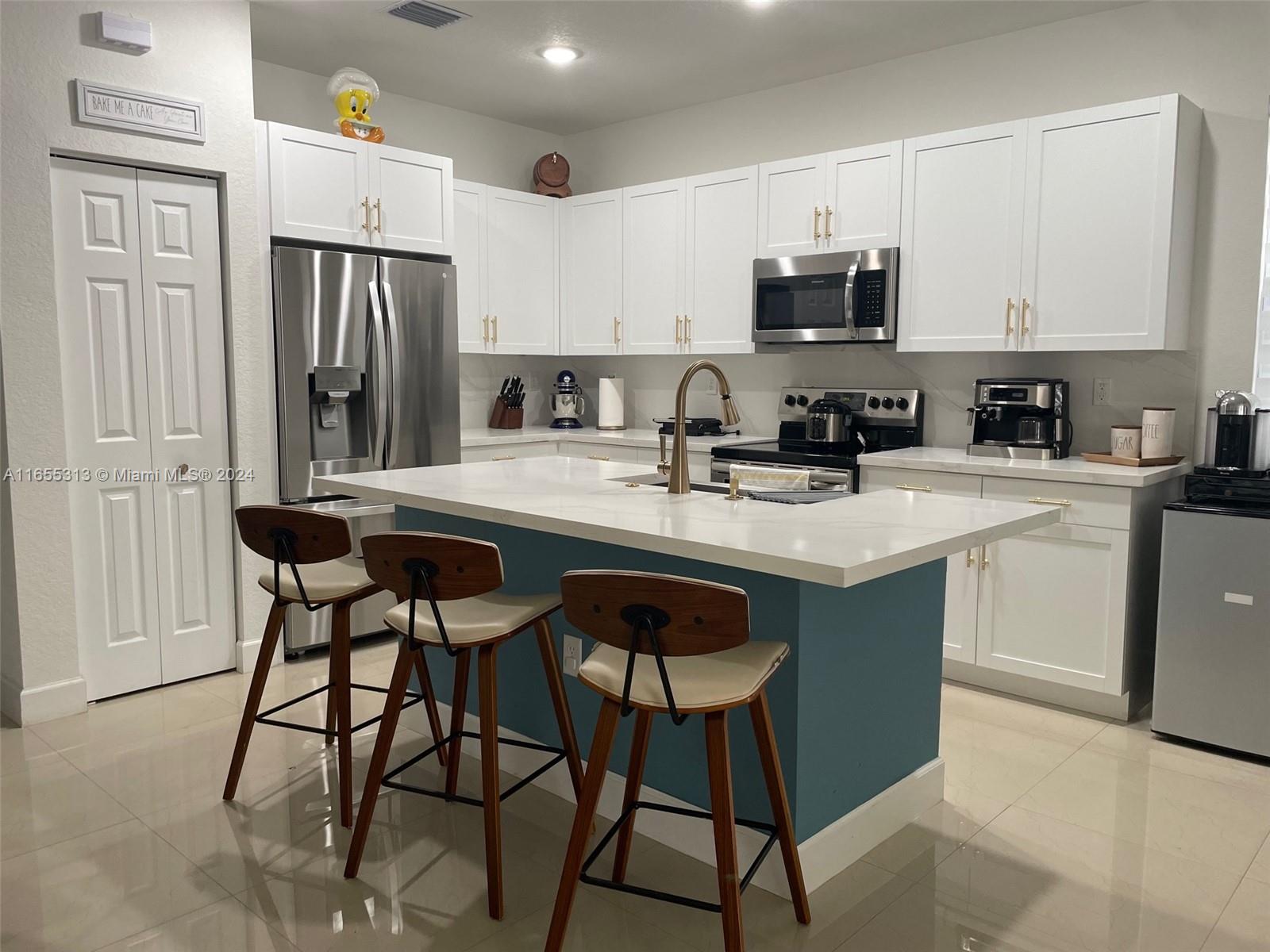 11015 West 35th Way Hialeah, FL 33018 - Photo 3 of 5 a kitchen with stainless steel appliances granite countertop a stove a sink dishwasher and a refrigerator with wooden cabinets