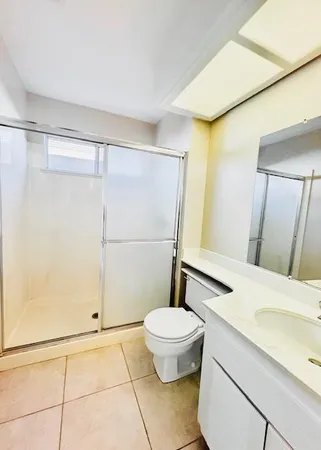 a bathroom with a sink a toilet a mirror and shower