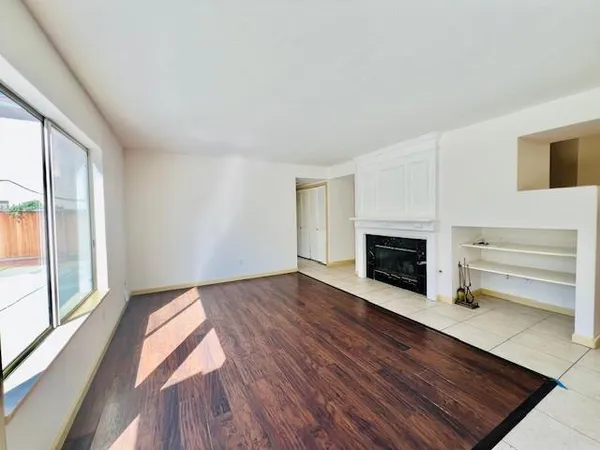 a view of a livingroom with wooden floor a fireplace and windows