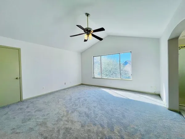 an empty room with windows and fan