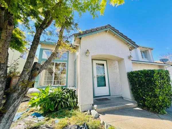 a view of a brick house with a large windows and flower plants
