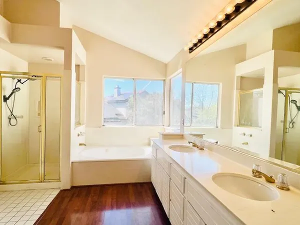 a bathroom with a tub sink and mirror