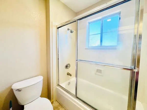 a bathroom with a toilet and a shower