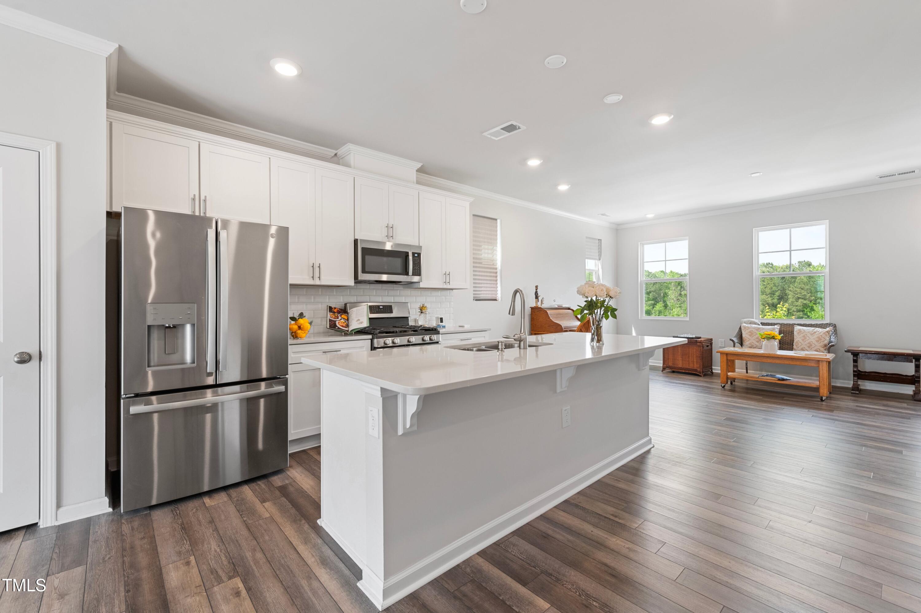 321 Devon Cliffs Drive Wake Forest, NC 27587 - Photo 7 of 26 a kitchen with kitchen island a refrigerator a stove a sink dishwasher with a dining table and chairs