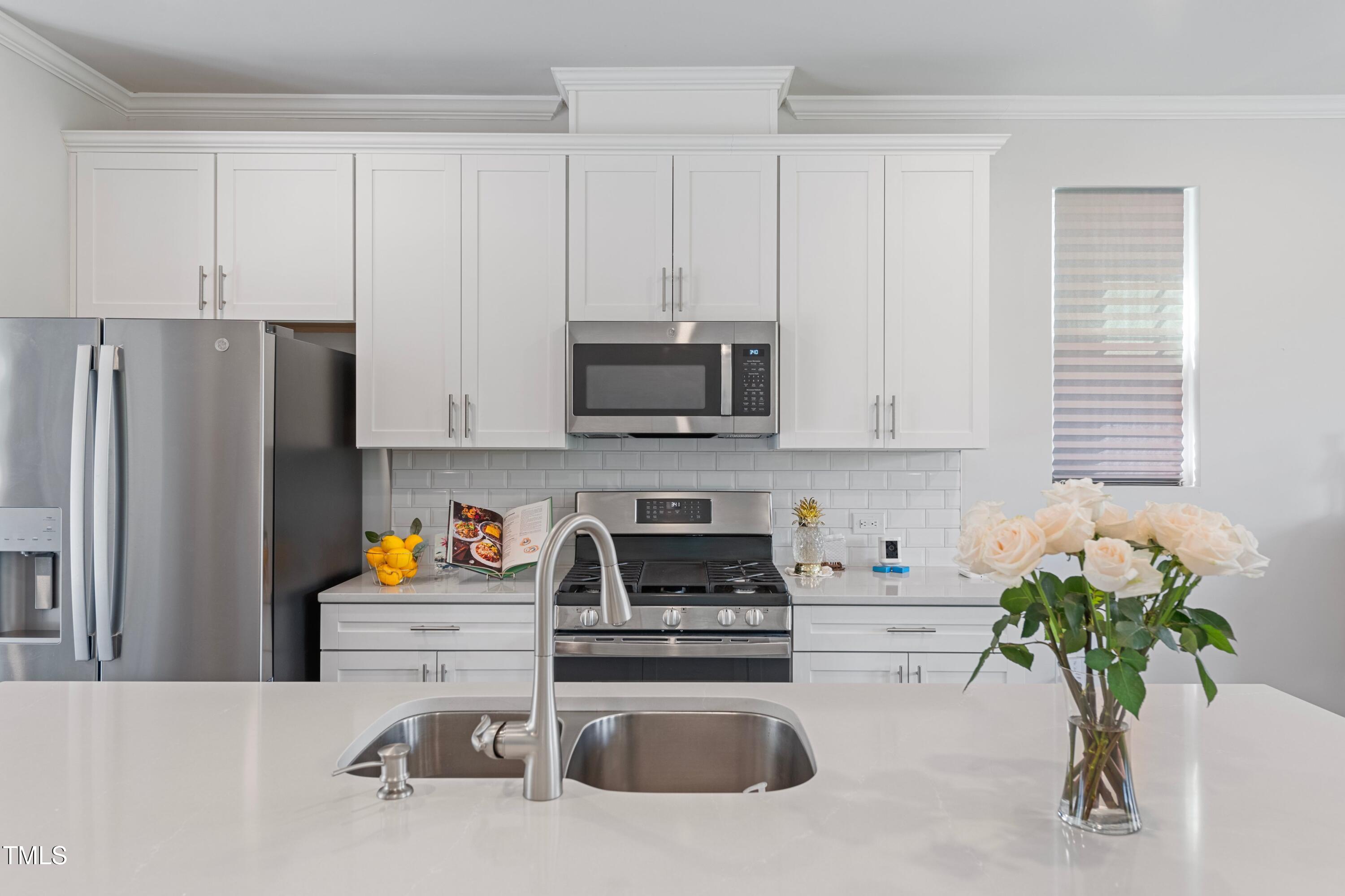 321 Devon Cliffs Drive Wake Forest, NC 27587 - Photo 9 of 26 a kitchen with stainless steel appliances a white refrigerator a stove a microwave a sink and cabinets