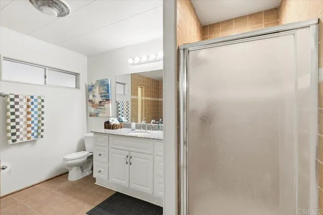 a bathroom with a granite countertop sink toilet and shower