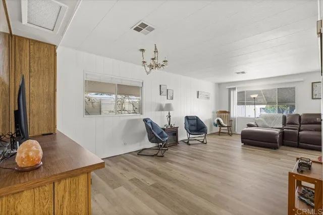 a living room with furniture a wooden floor and potted plant