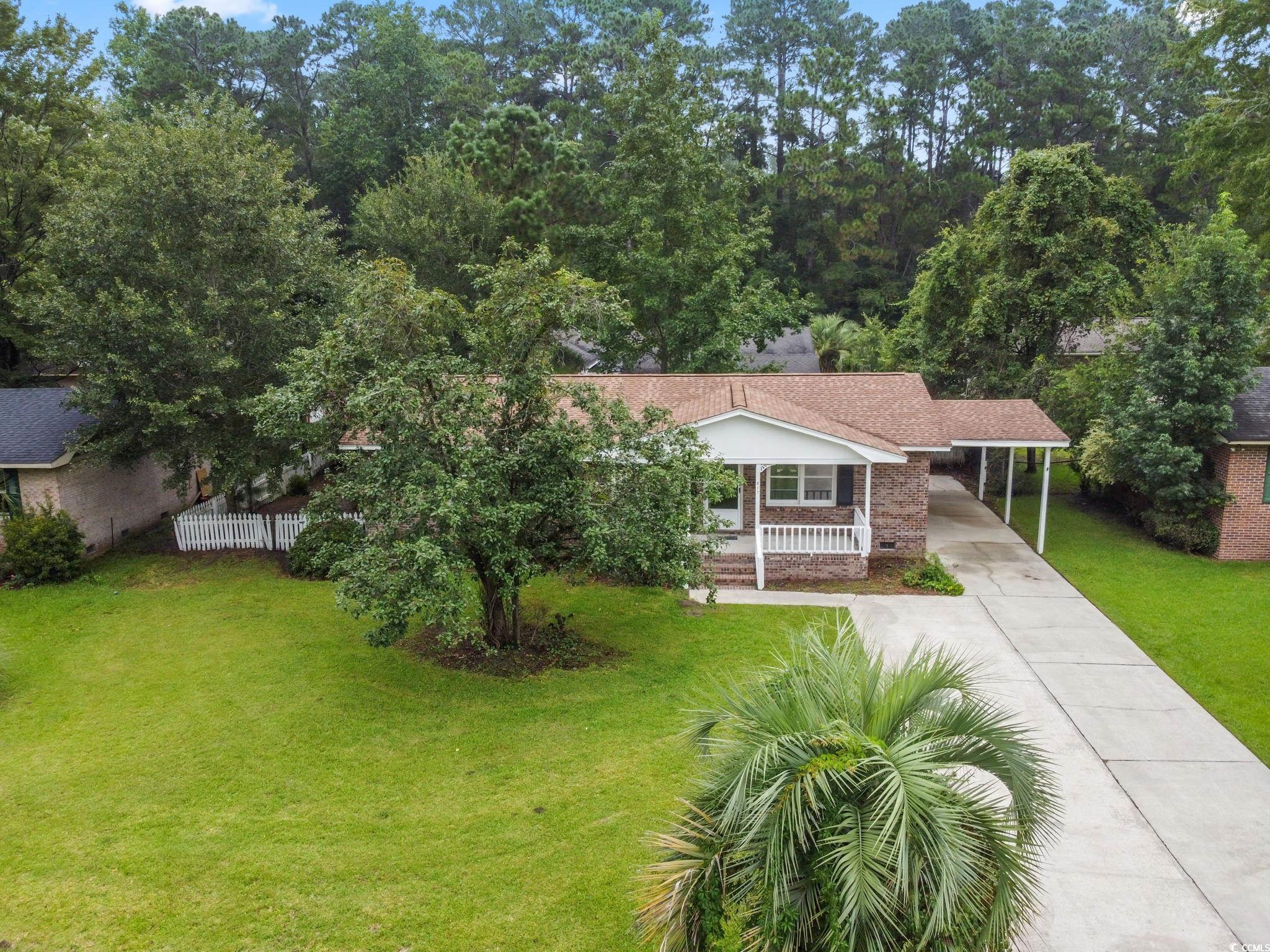 617 Truman Road Conway, SC 29526 - Photo 3 of 40 View of front facade with a front yard, covered porch, concrete driveway, brick siding, and a carport
