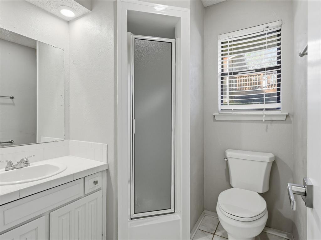 1811 Briarcrest Lane Arlington, TX 76012 - Photo 16 of 29 a bathroom with a toilet a sink a vanity and mirror