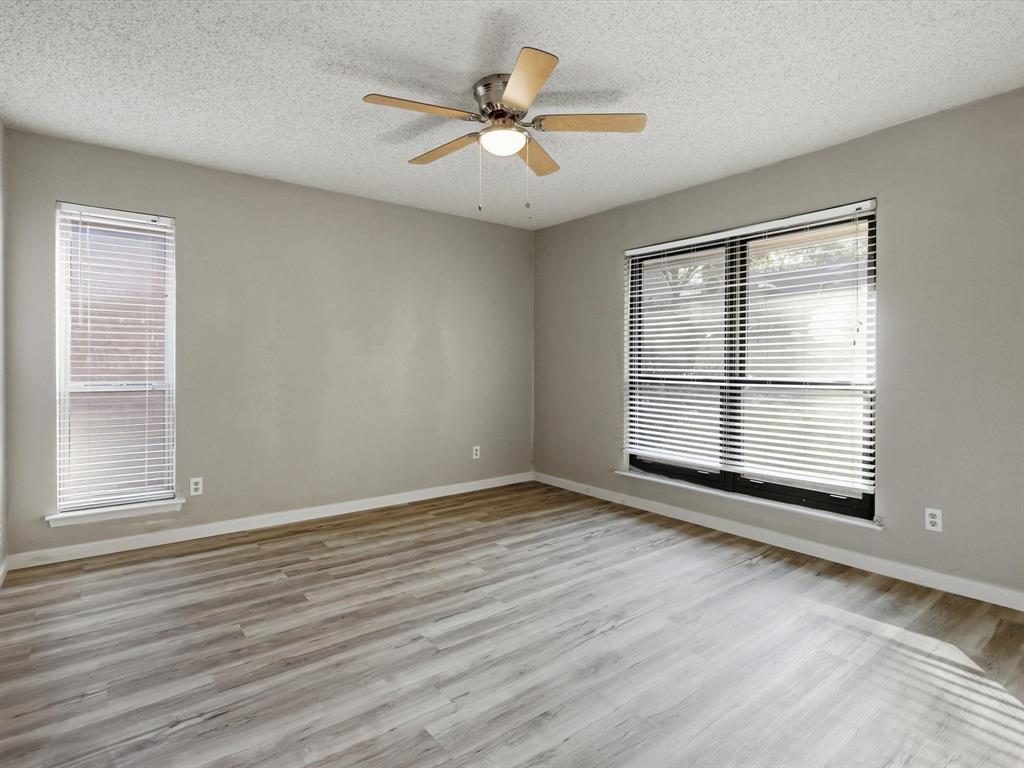 1811 Briarcrest Lane Arlington, TX 76012 - Photo 23 of 29 a view of an empty room with wooden floor and a window