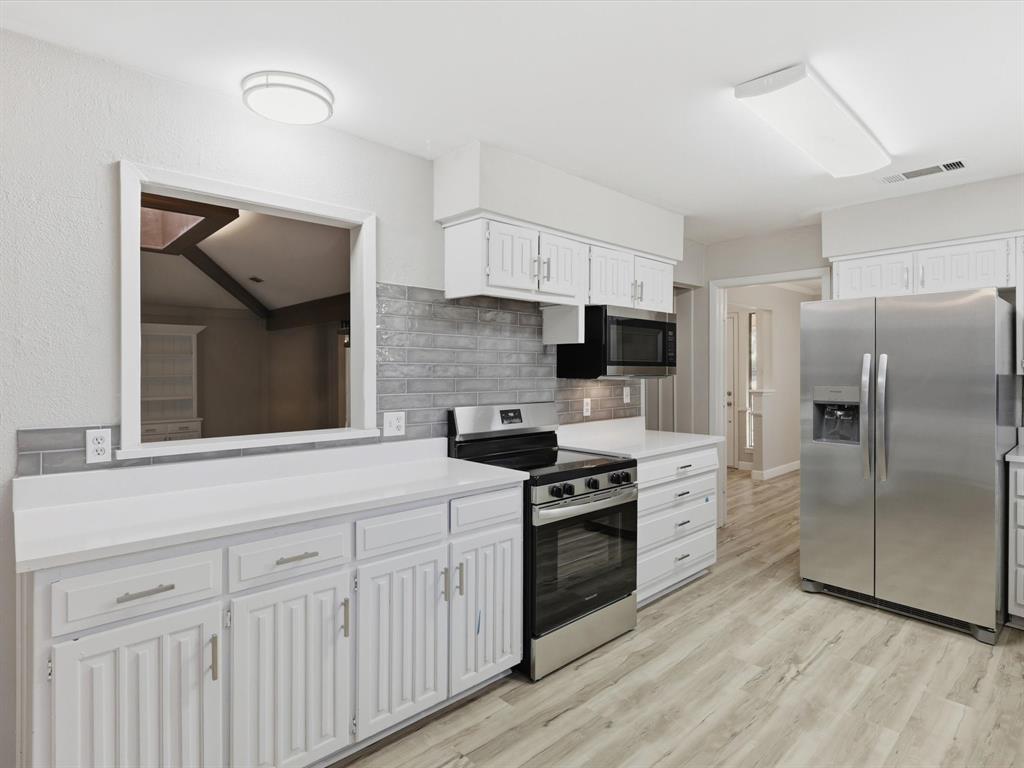 1811 Briarcrest Lane Arlington, TX 76012 - Photo 6 of 29 a kitchen with cabinets stainless steel appliances and wooden floor