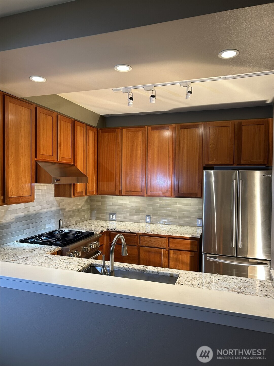 1900 Alaskan Way, Unit 402 Seattle, WA 98101 - Photo 11 of 32 a kitchen with granite countertop a refrigerator and a sink