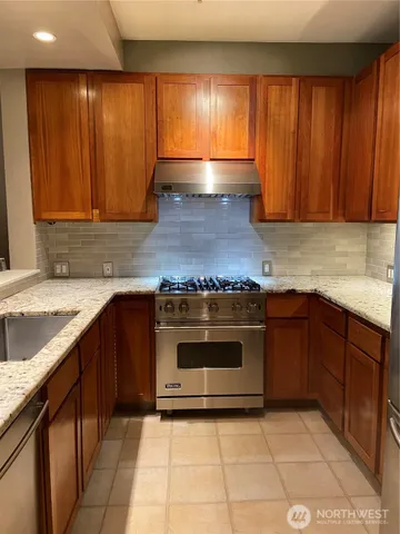 a view of kitchen with granite countertop a sink and a counter top space