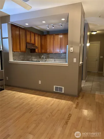 a kitchen with granite countertop a refrigerator and a sink