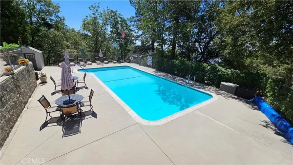 a view of a swimming pool with chairs in backyard