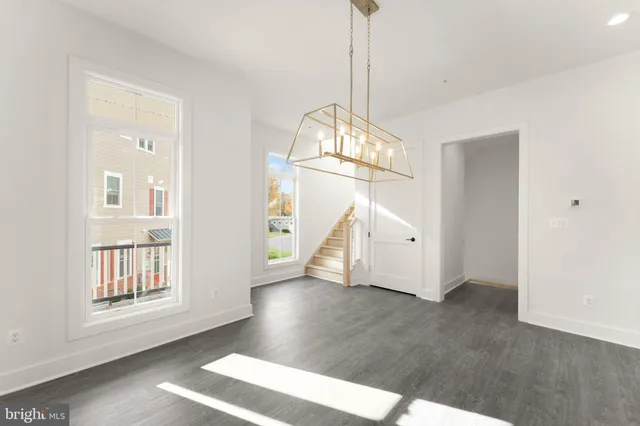 a large kitchen with kitchen island white cabinets and a wooden floor