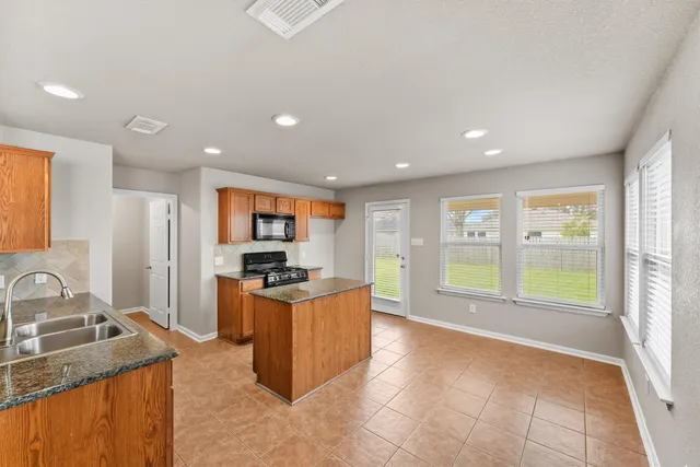 a large kitchen with stainless steel appliances granite countertop a sink and a stove