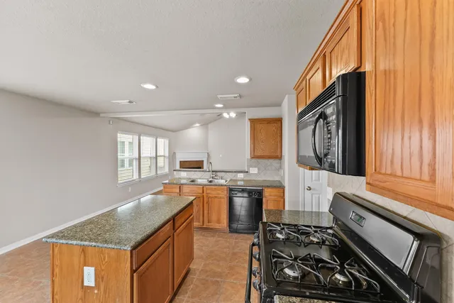 a kitchen with stainless steel appliances granite countertop a sink stove and cabinets