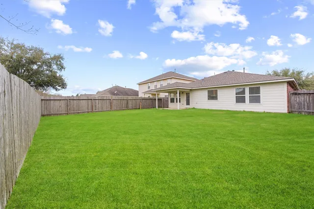 a view of a house with a big yard and large trees