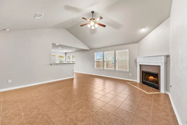 a view of an empty room with a fireplace and a window