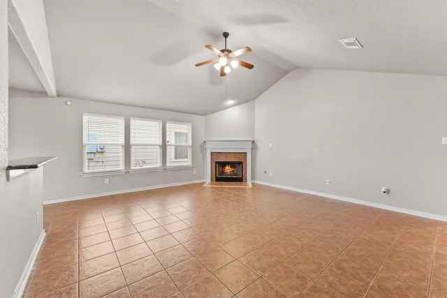 a view of an empty room with a fireplace and a window