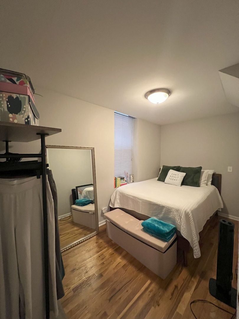 1532 West 18th Place, Unit 1F Chicago, IL 60608 - Photo 12 of 14 a bedroom with a bed and a flat tv screen on a dresser