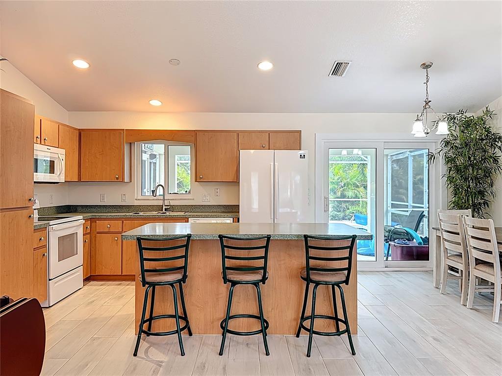 2500 Allegheny Lane North Port, FL 34286 - Photo 13 of 46 a kitchen with stainless steel appliances a dining table chairs and wooden floor