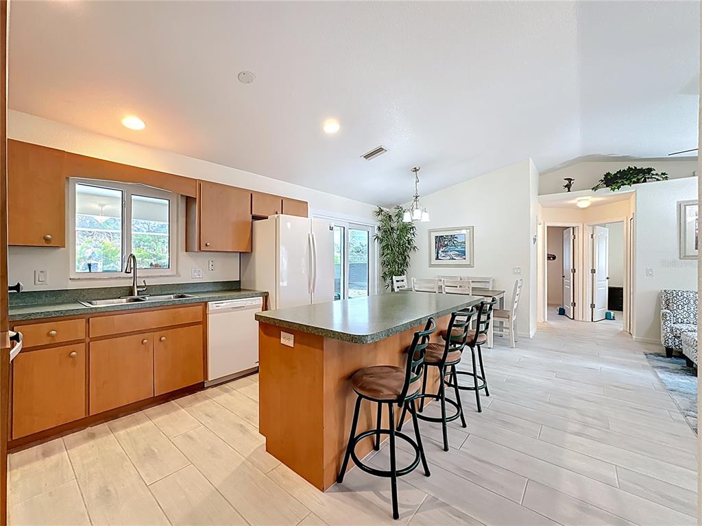 2500 Allegheny Lane North Port, FL 34286 - Photo 14 of 46 a kitchen with stainless steel appliances granite countertop a table chairs refrigerator and sink