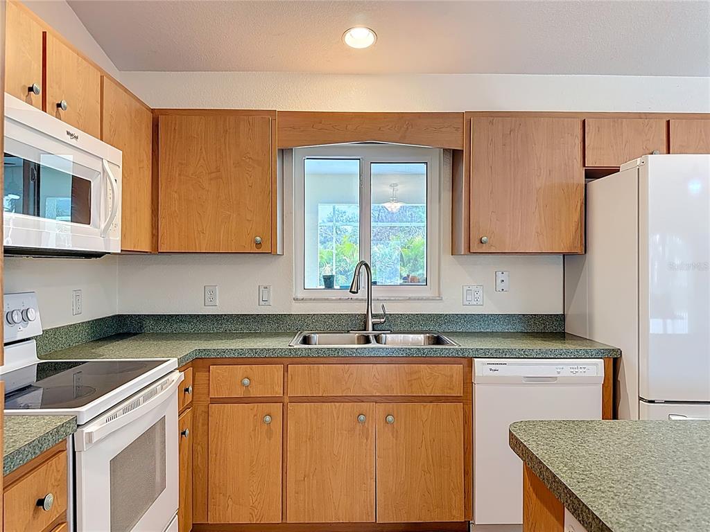 2500 Allegheny Lane North Port, FL 34286 - Photo 17 of 46 a kitchen with stainless steel appliances granite countertop a sink stove and refrigerator