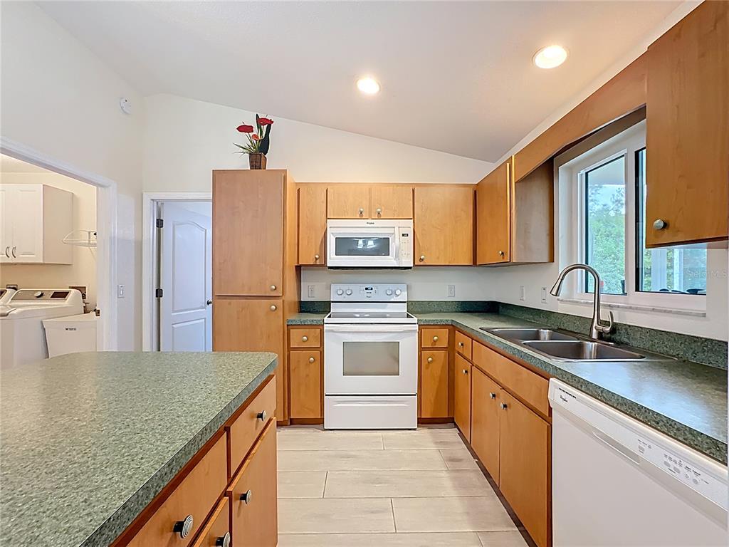 2500 Allegheny Lane North Port, FL 34286 - Photo 19 of 46 a kitchen with stainless steel appliances granite countertop a sink stove refrigerator and cabinets