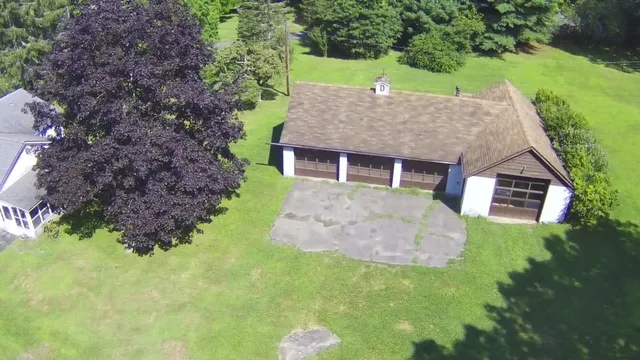 a aerial view of a house with a yard table and chairs