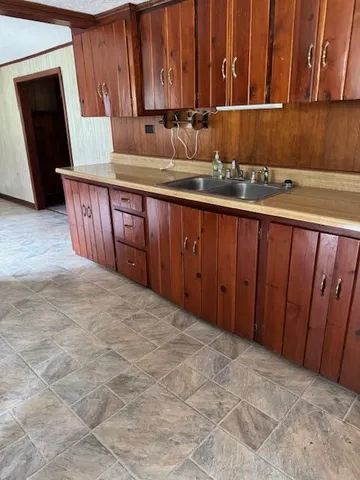 view of kitchen with stainless steel appliances granite countertop wooden cabinets a sink and dishwasher