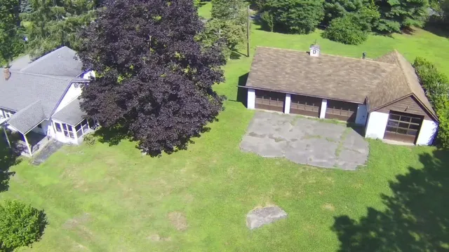 a aerial view of a house with a yard and large tree