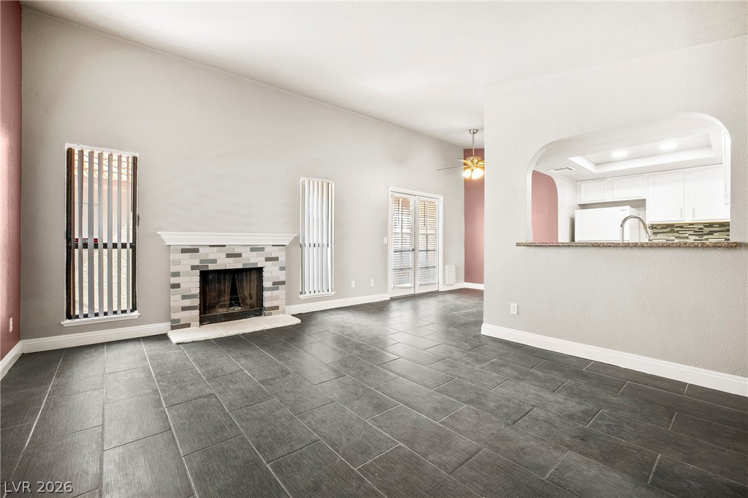 3311 Sunfish Drive, Unit D Henderson, NV 89014 - Photo 6 of 21 A spacious living area with a fireplace and modern tiled flooring offers a comfortable atmosphere.