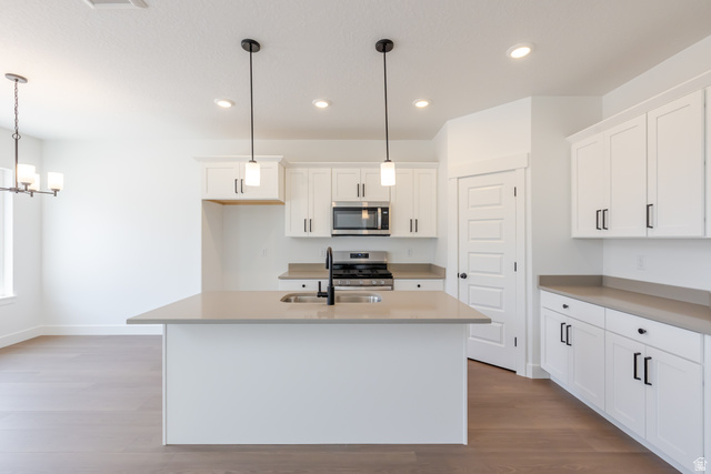 5224 South Acacia Drive, Unit 809 Mapleton, UT 84664 - Photo 12 of 23 Kitchen featuring a central island with an undermount sink, white cabinetry with matte black hardware, stainless steel appliances, and recessed lighting