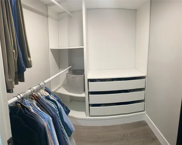 a view of walk in closet with clothes