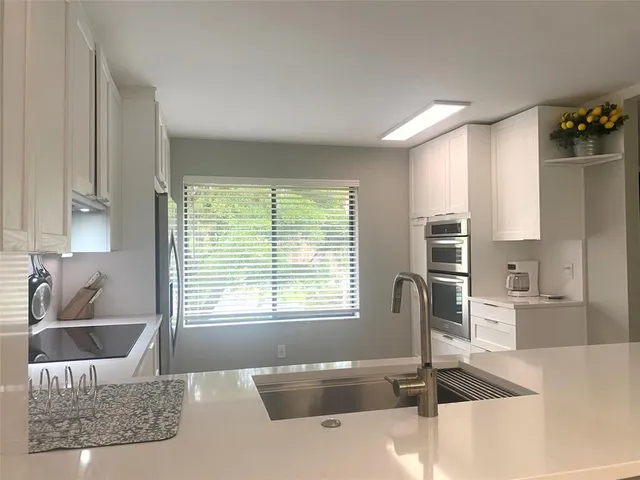 a bathroom with a granite countertop sink a bathtub and next to a window