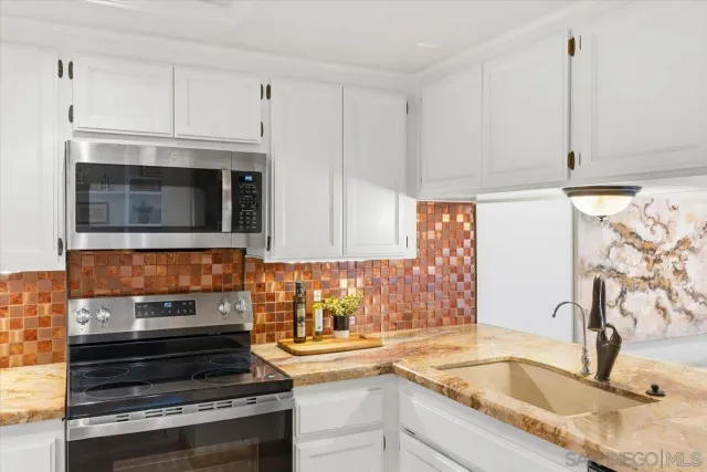 a kitchen with granite countertop a stove and a sink