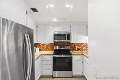 a kitchen with stainless steel appliances granite countertop a refrigerator and a stove