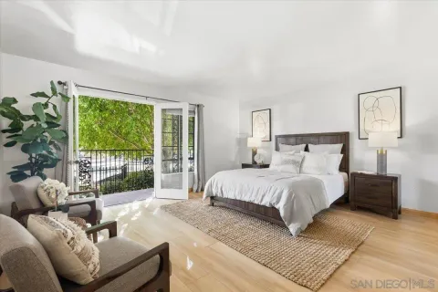 a spacious bedroom with a bed and a couch next to a window