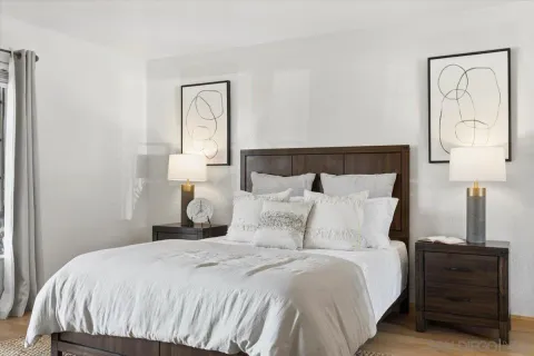 a bedroom with a bed and a lamp on dresser