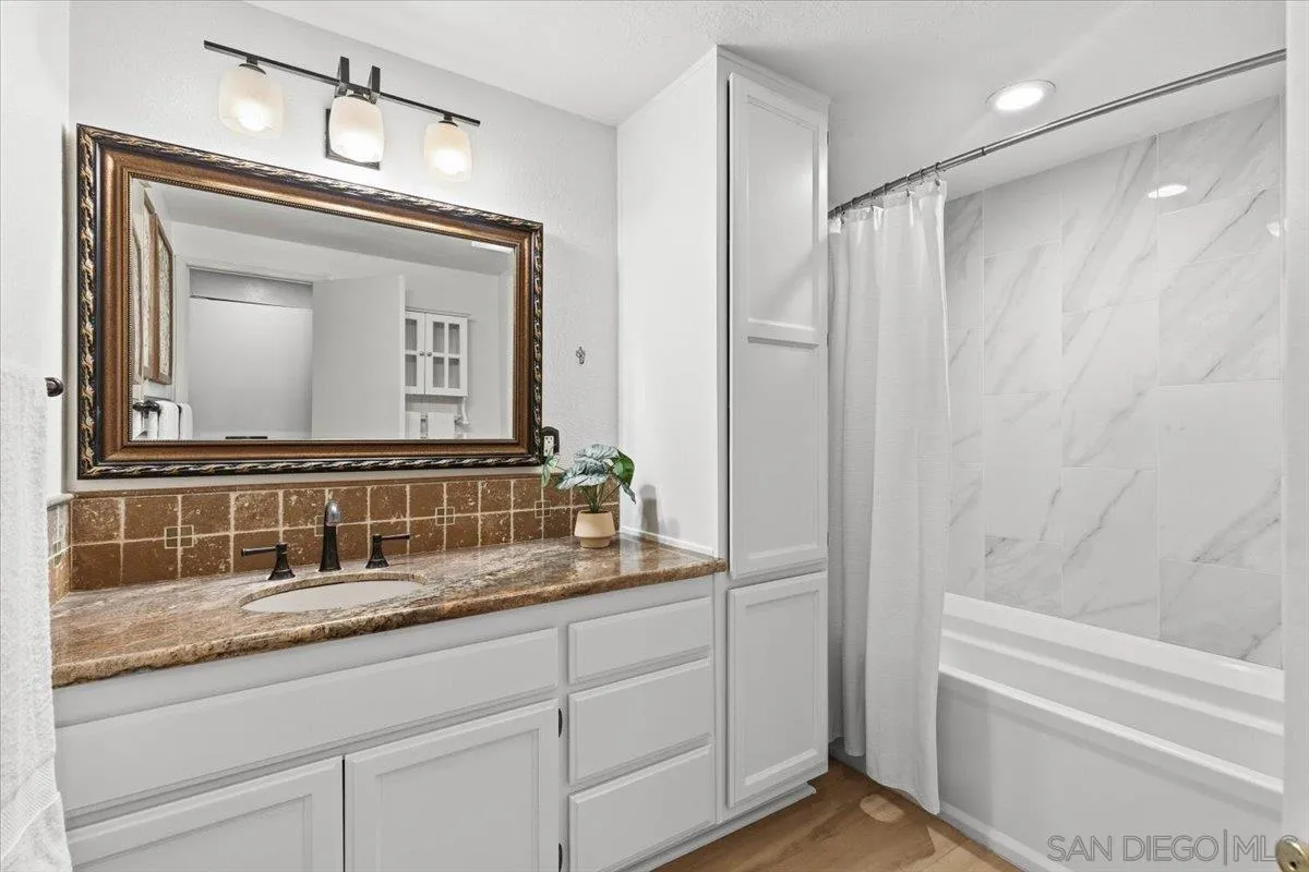 2630 Pirineos Way, Unit 5 Carlsbad, CA 92009 - Photo 19 of 48 a bathroom with a granite countertop sink a mirror and a bathtub