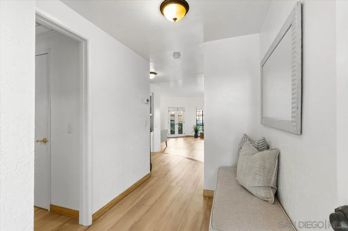 2630 Pirineos Way, Unit 5 Carlsbad, CA 92009 - Photo 2 of 48 a view of a hallway with wooden floor and furniture