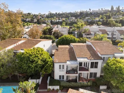 an aerial view of residential houses with outdoor space and trees