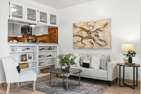 a living room with furniture cabinets and a potted plant