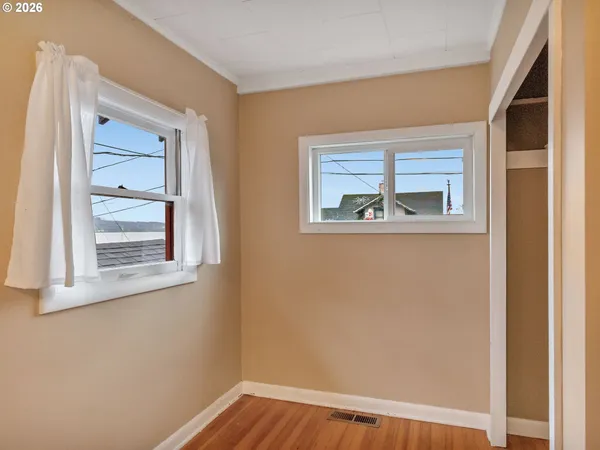 a view of a small space with wooden floor and a window
