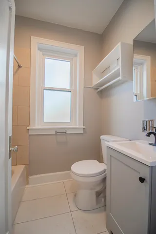 a bathroom with a toilet sink and window