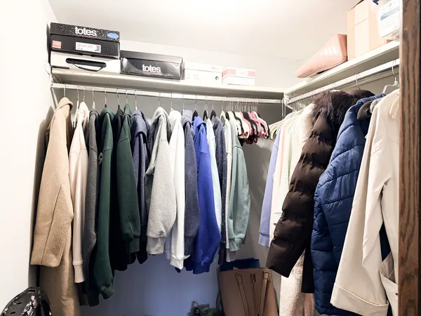 a view of walk in closet with clothes and shoes