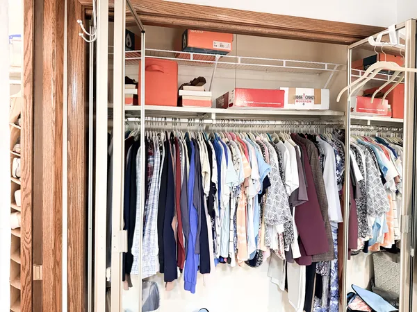 a view of walk in closet with clothes and shoes